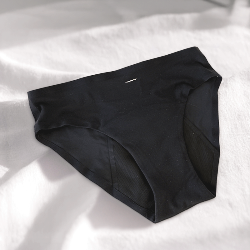 Black underwear on a white bed